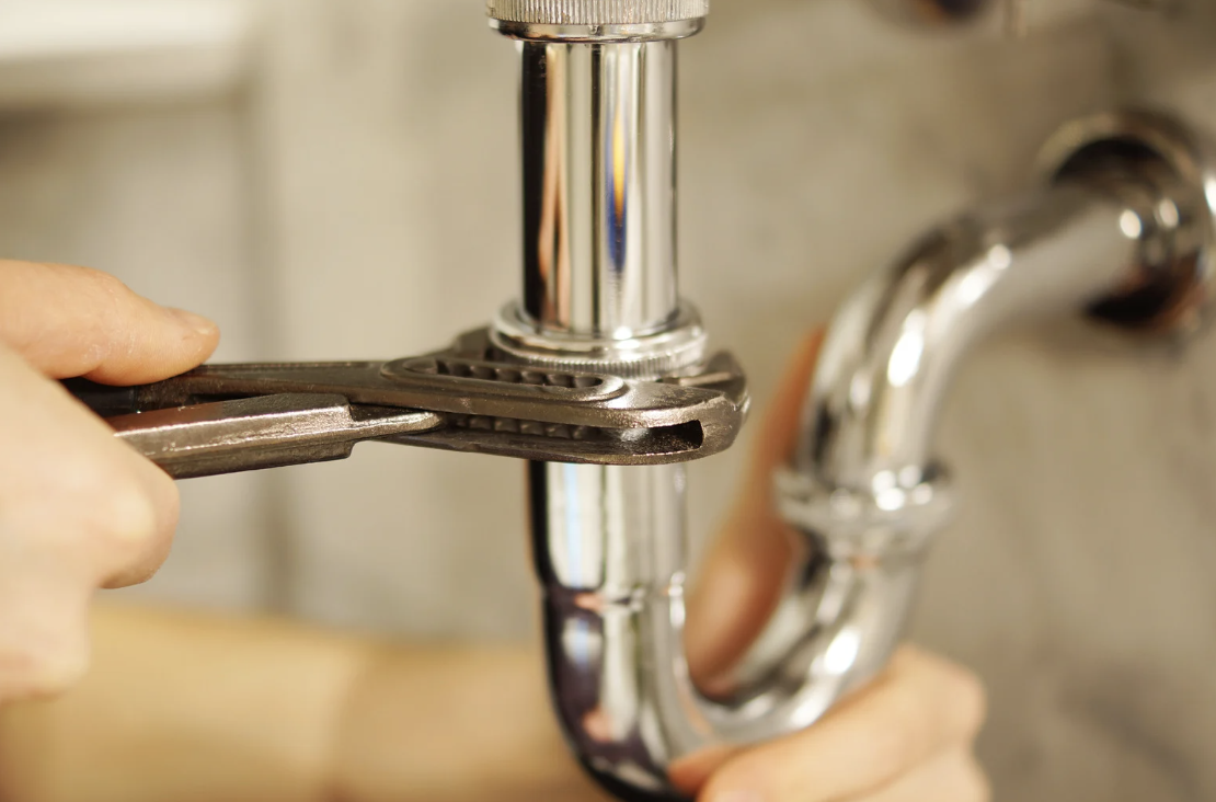 wrench around a metal faucet pipe